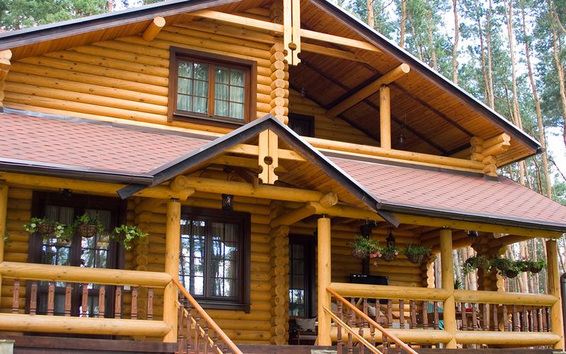 Log cabin home with a covered porch, built with lumber and log home supplies